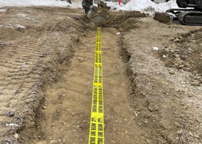 Toncar digging trench near silver buildings